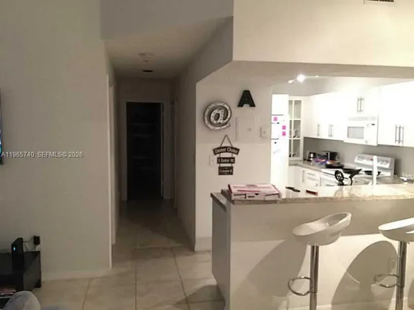 a kitchen with stainless steel appliances kitchen island granite countertop a refrigerator and a stove