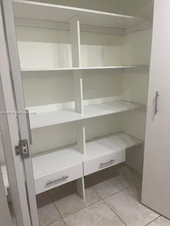 a view of walk in closet with empty racks
