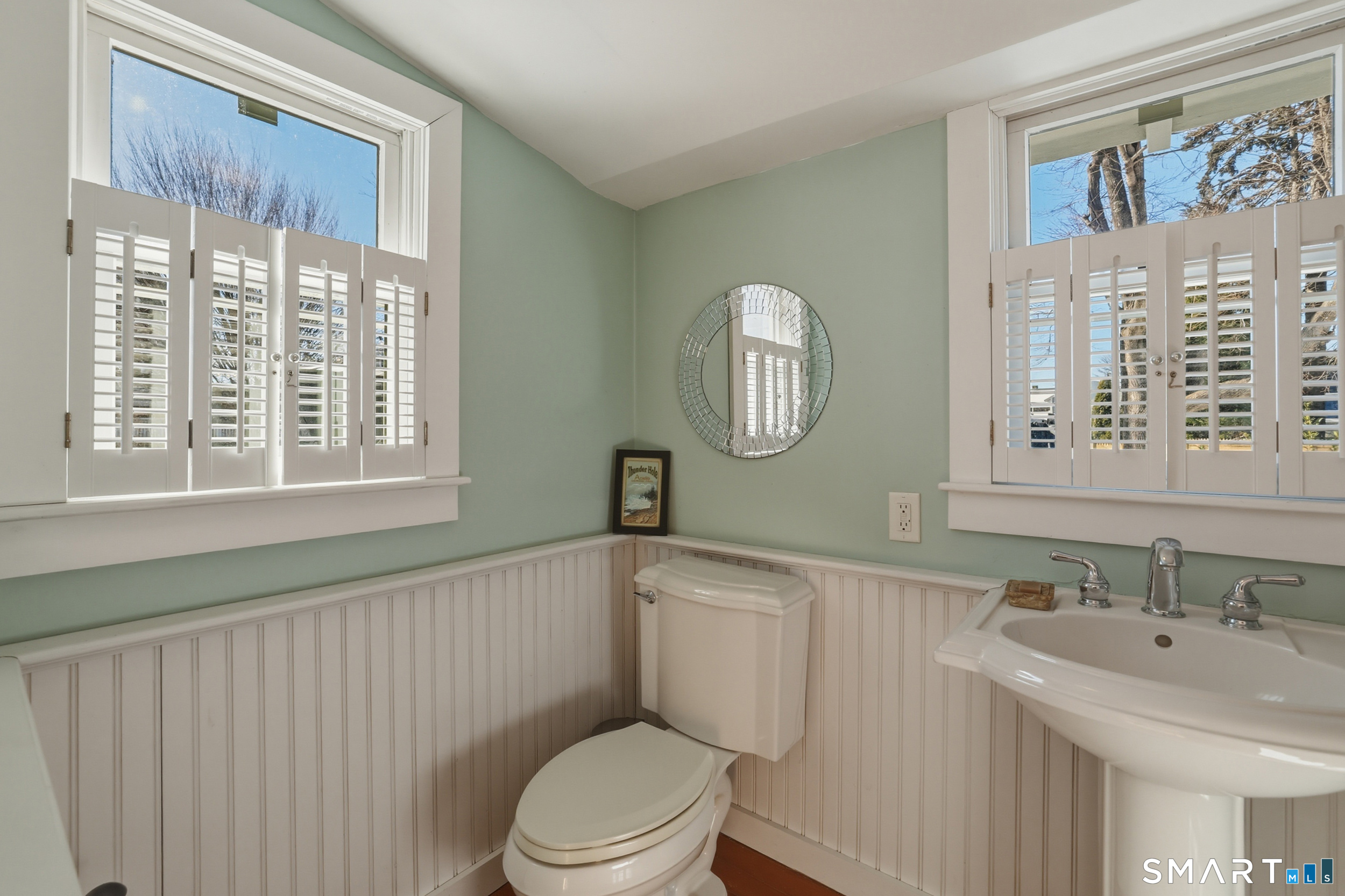 11 Tuxis Road Madison, CT 06443 - Photo 16 of 40 Full bath with shower on the main level featuring wood flooring, bead-board wall accent, and plantation shutters.