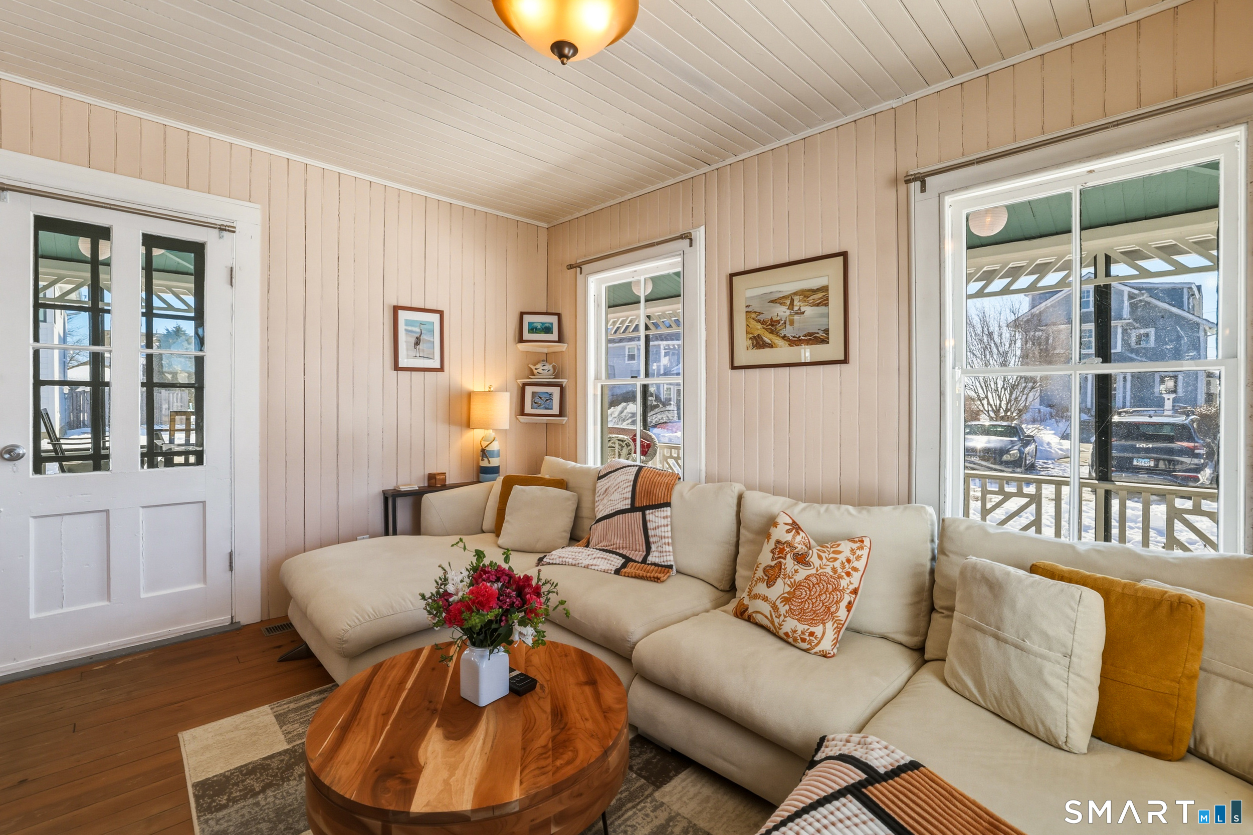 11 Tuxis Road Madison, CT 06443 - Photo 9 of 40 Inviting living room with wood floors, shiplap walls and ceiling, and direct access to the screened wraparound porch.