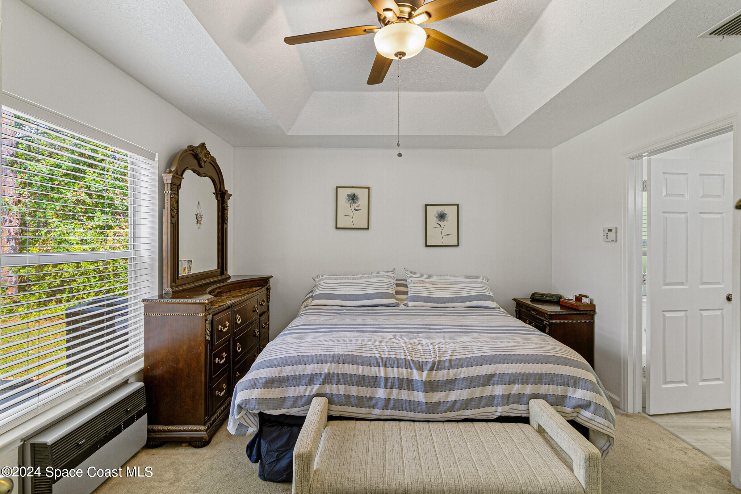 931 Pandora Road Southeast Palm Bay, FL 32909 - Photo 19 of 34 a bedroom with a bed and a flat tv screen on the dresser