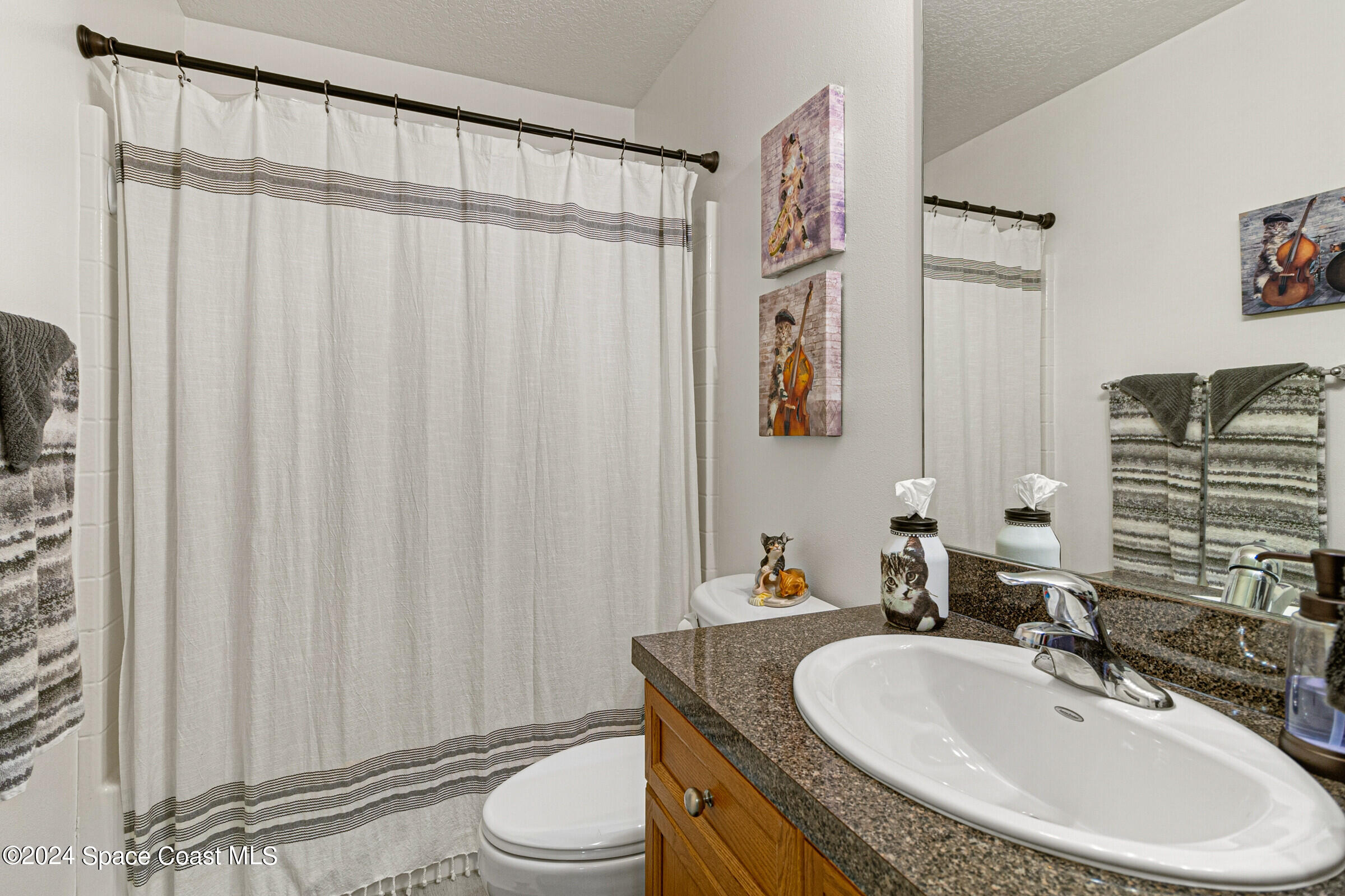 931 Pandora Road Southeast Palm Bay, FL 32909 - Photo 25 of 34 a bathroom with a granite countertop sink and a mirror