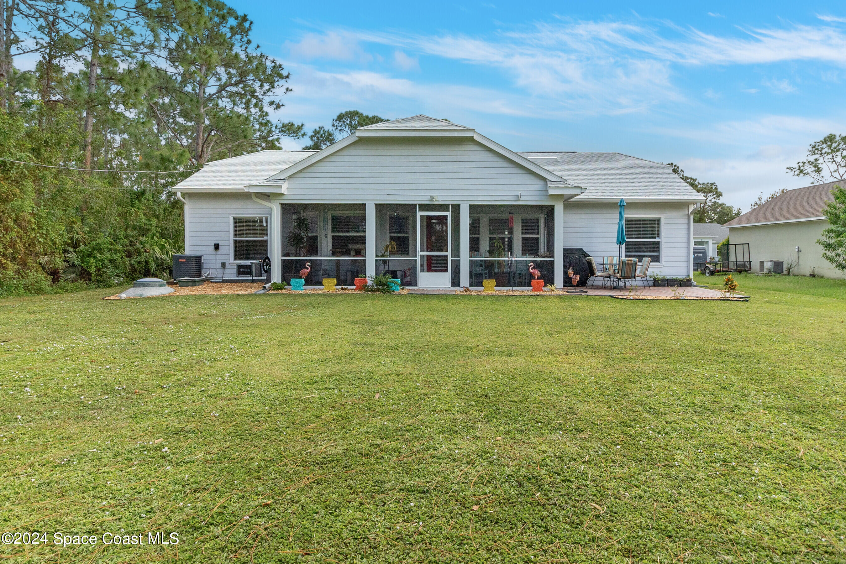 931 Pandora Road Southeast Palm Bay, FL 32909 - Photo 30 of 34 a view of a house with a big yard and large trees