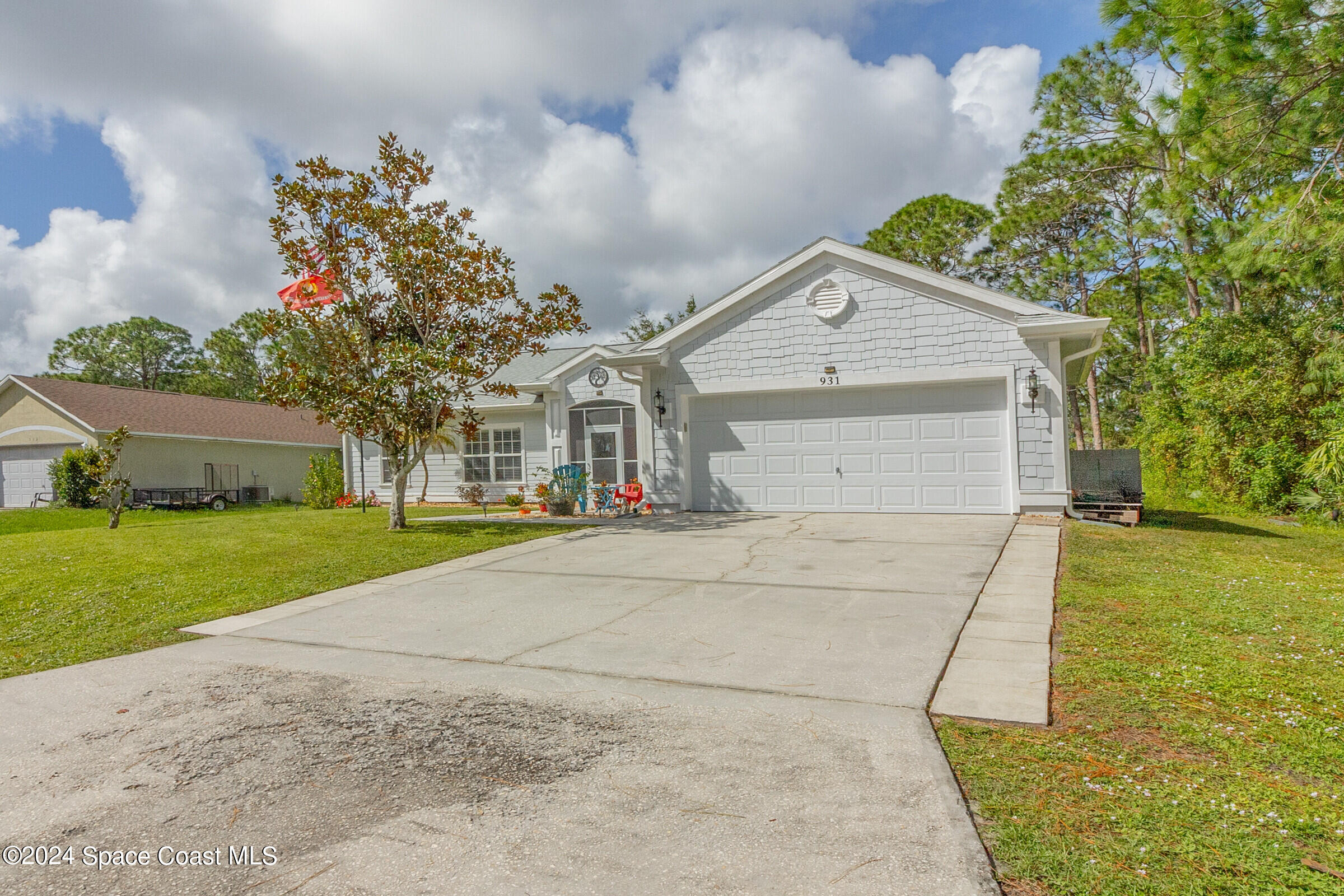 931 Pandora Road Southeast Palm Bay, FL 32909 - Photo 34 of 34 a front view of a house with a yard and garage