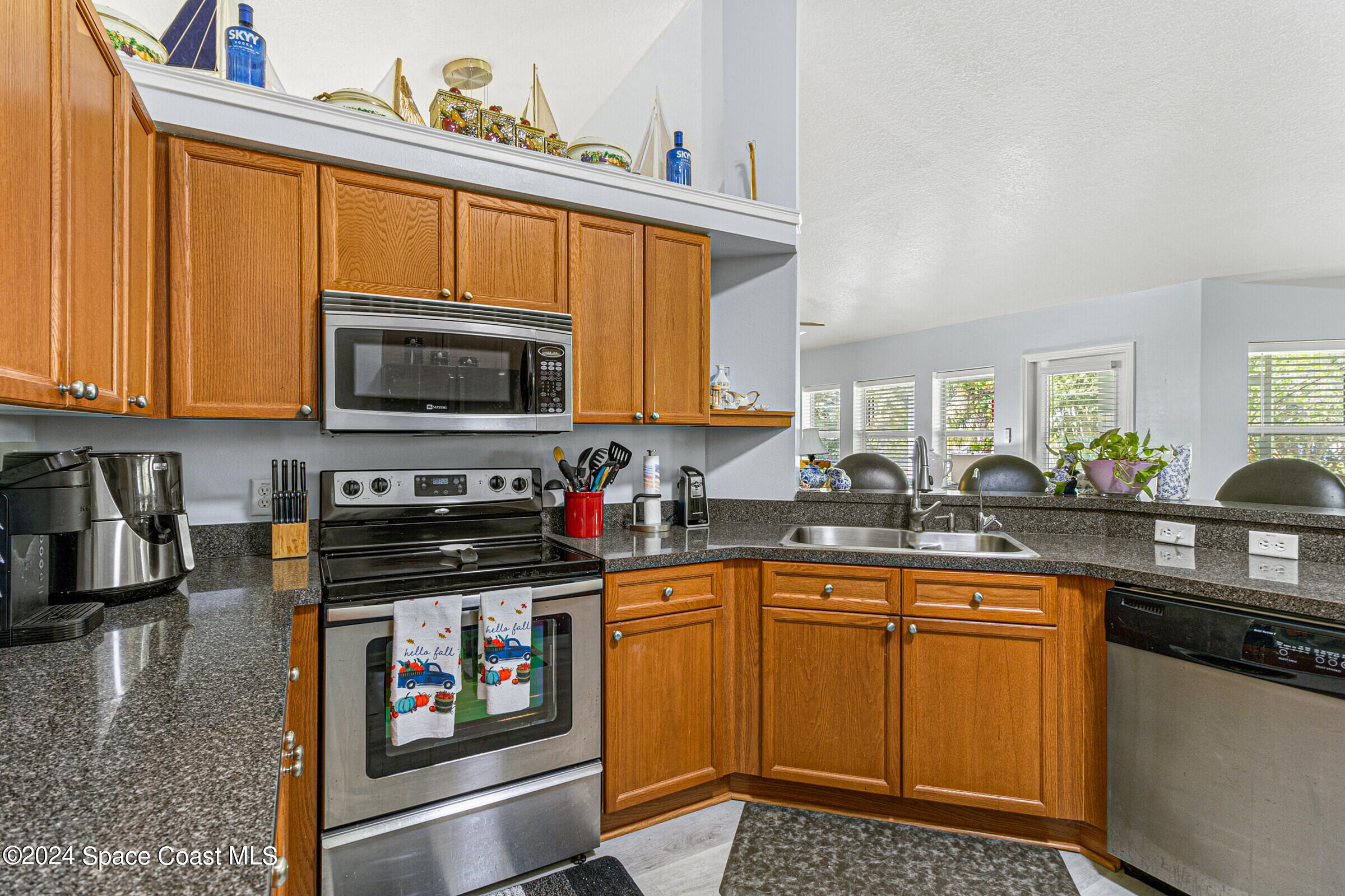 931 Pandora Road Southeast Palm Bay, FL 32909 - Photo 4 of 34 a kitchen with stainless steel appliances a stove sink microwave and cabinets