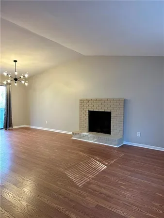 a view of empty room with wooden floor and fireplace