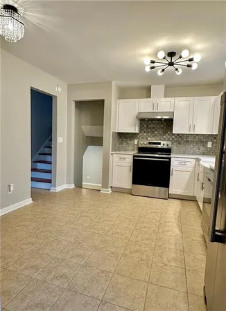 a view of a kitchen with a sink and dishwasher a stove top oven with wooden floor