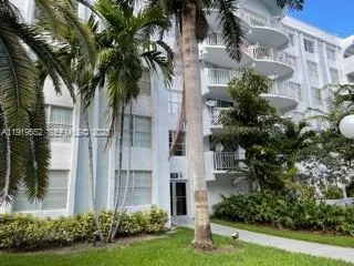 a front view of multi story residential apartment building with yard and green space