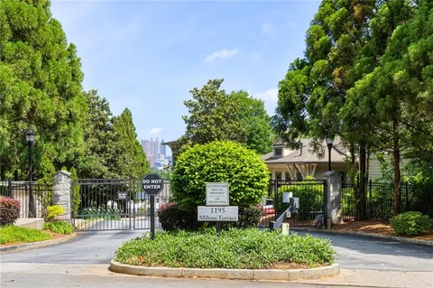 a front view of a house with a yard and potted plants