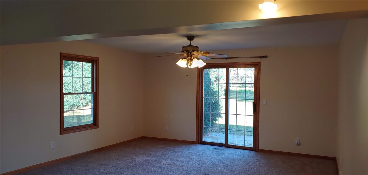 20979 Free Church Road Caledonia, IL 61011 - Photo 16 of 40 an empty room with windows and chandelier fan