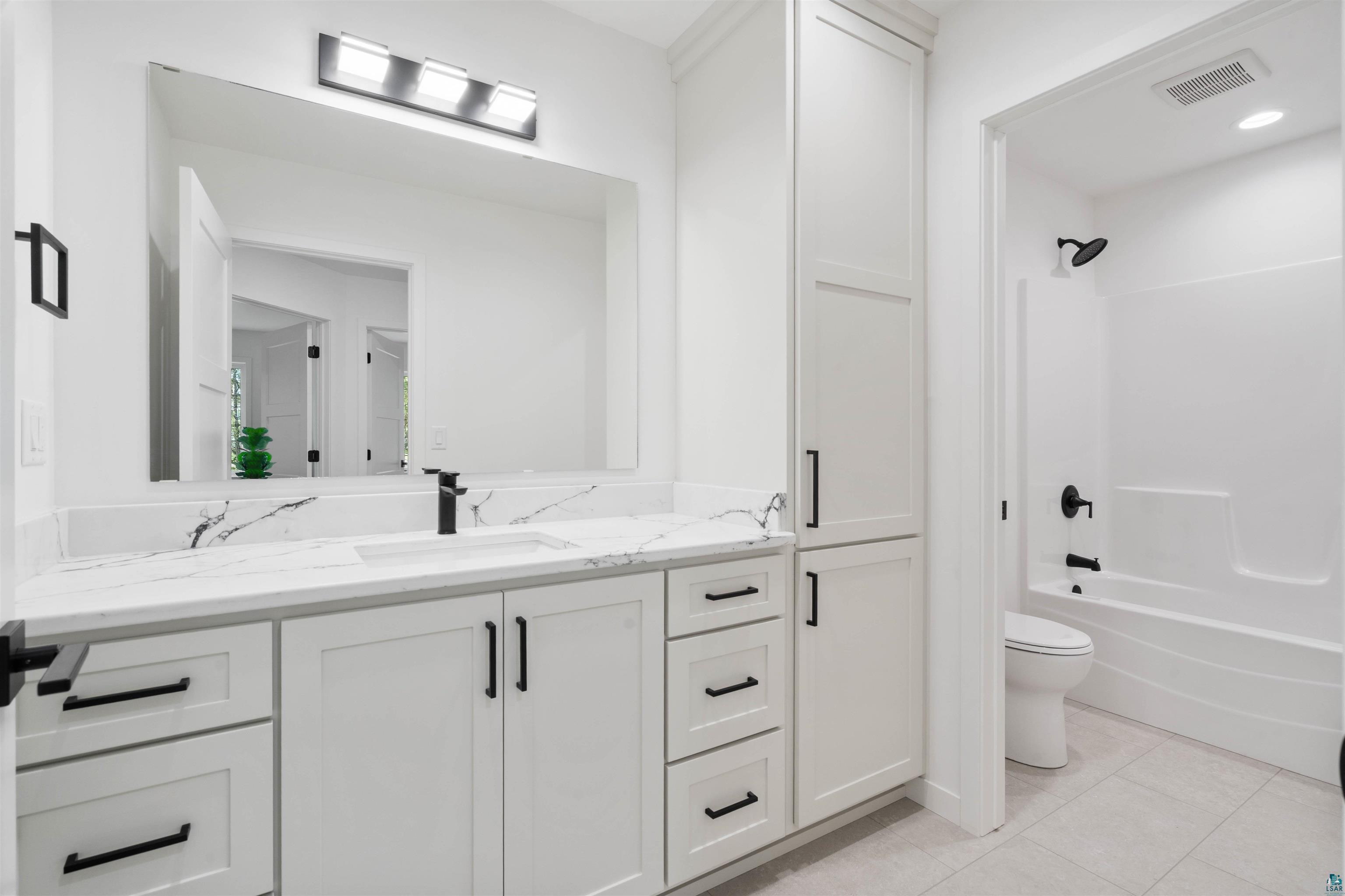 1386 Stephen Road Cloquet, MN 55720 - Photo 18 of 25 Contemporary bathroom featuring a white vanity with a veined countertop, integrated sink, and matte black faucet
