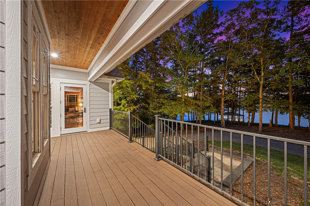 285 Bertha Allen Road Westminster, SC 29693 - Photo 29 of 50 A spacious outdoor deck with wood paneling offers serene lake views at dusk.