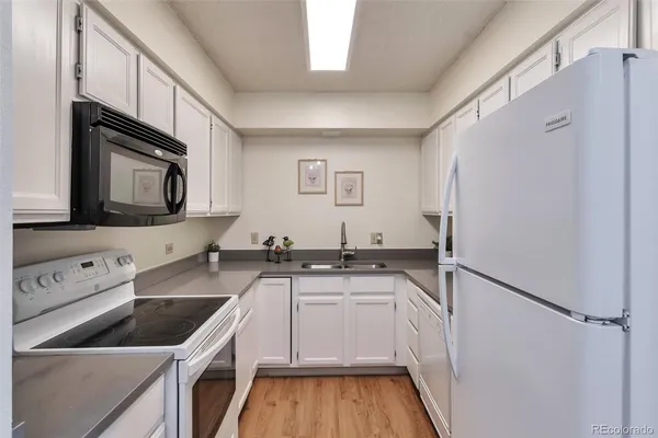a kitchen with a sink a refrigerator and cabinets