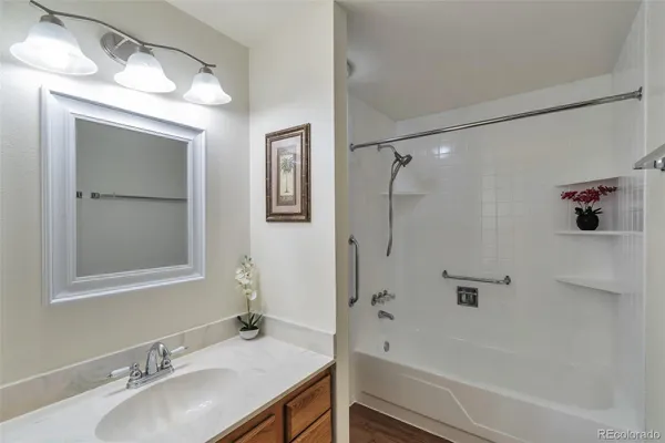 a bathroom with a granite countertop sink a mirror and a bathtub