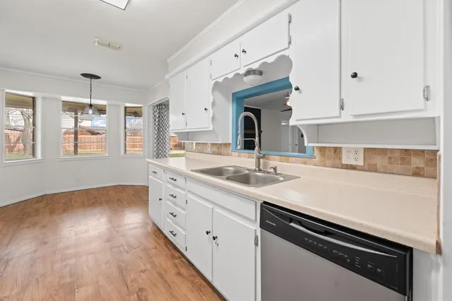 a kitchen with granite countertop cabinets stainless steel appliances and wooden floor