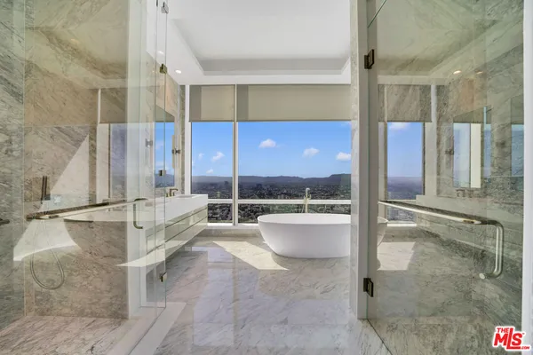a view of a bathroom with a tub shower and mirror