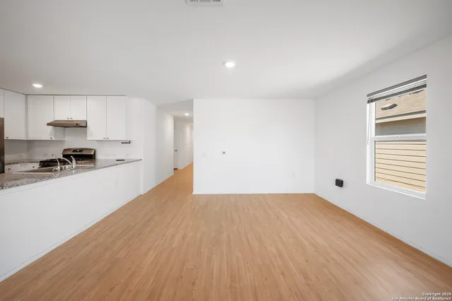 a view of a kitchen with wooden floor and a sink