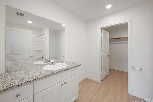 a bathroom with a granite countertop sink and a mirror