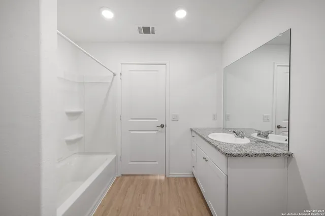 a bathroom with a granite countertop sink a toilet and shower