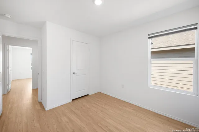 a view of a room with wooden floor and a window
