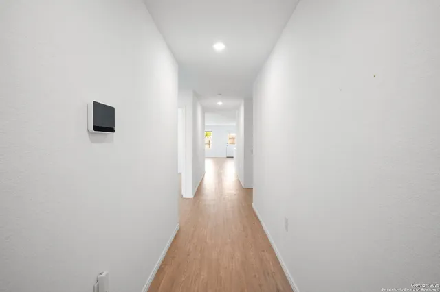 a view of a hallway with wooden floor
