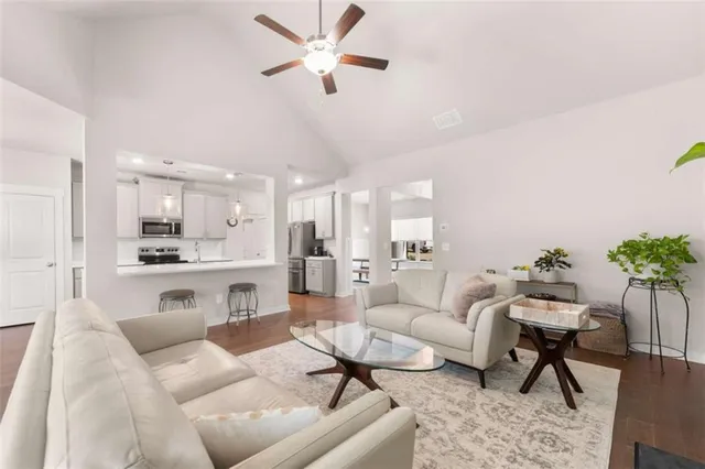 a living room with furniture white walls and a chandelier