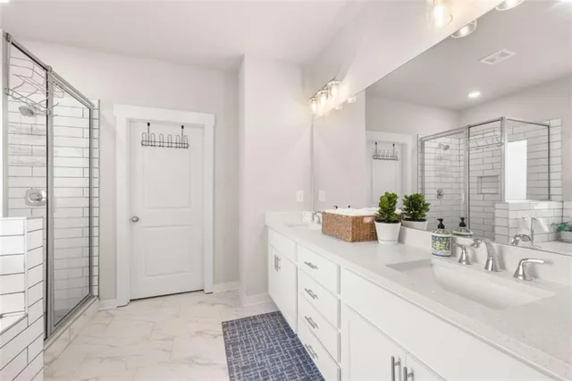 a bathroom with double vanity and a mirror