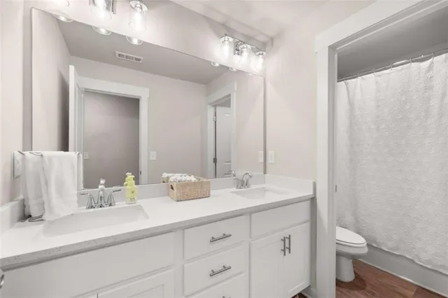 a bathroom with double sink and a mirror