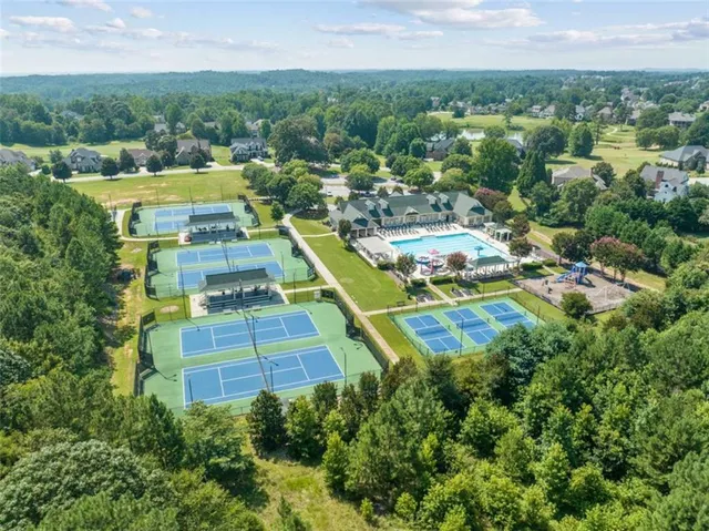 an aerial view of residential houses with outdoor space and trees