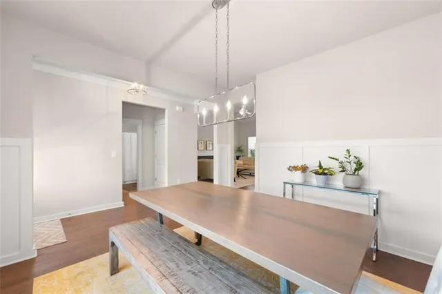 a room with kitchen island a chandelier and wooden floor
