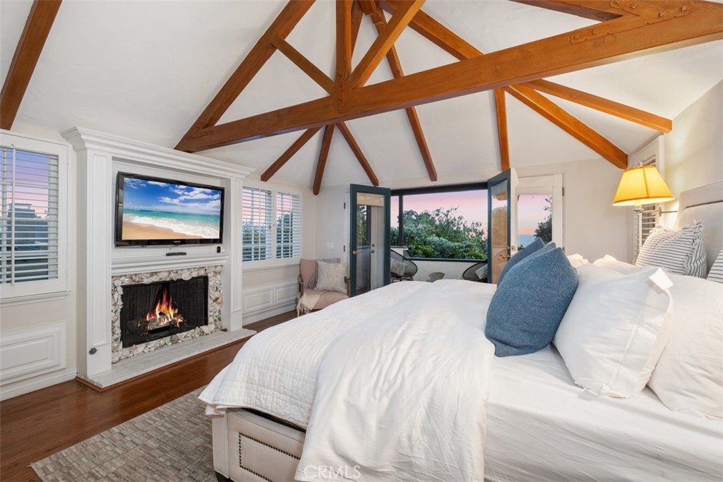 421 High Drive Laguna Beach, CA 92651 - Photo 19 of 42 a large bed sitting in a living room next to a fireplace