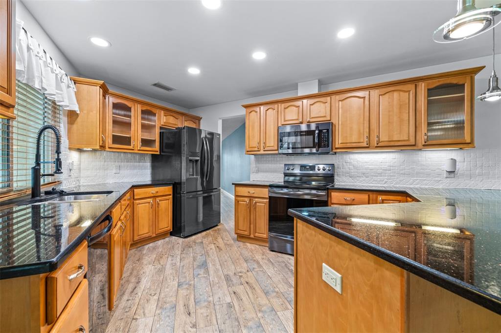 3404 Brian Road South Palm Harbor, FL 34685 - Photo 14 of 71 a kitchen with stainless steel appliances granite countertop a stove a sink and a refrigerator