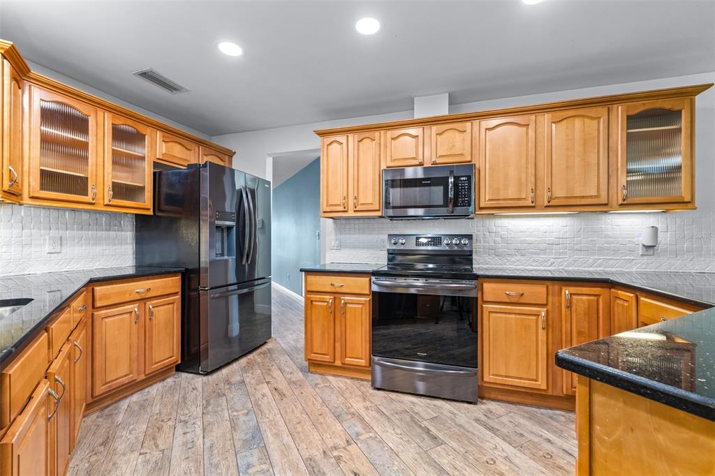 3404 Brian Road South Palm Harbor, FL 34685 - Photo 15 of 71 a kitchen with stainless steel appliances granite countertop a refrigerator sink and stove