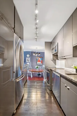 a kitchen with granite countertop a sink appliances and cabinets