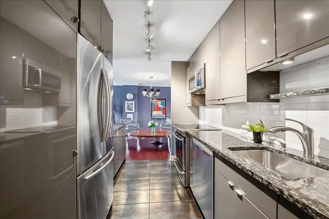 a kitchen with kitchen island granite countertop a stove a sink and a refrigerator