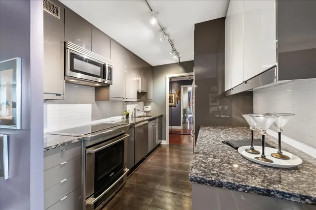 a very nice looking dining room with kitchen island furniture a chandelier and wooden floor