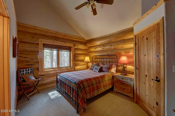 a bedroom with a bed and a dresser next to a window