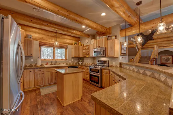 a kitchen with stainless steel appliances granite countertop a sink a stove and a refrigerator