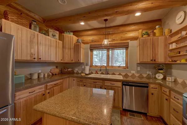 a kitchen with stainless steel appliances granite countertop a sink a stove and cabinets