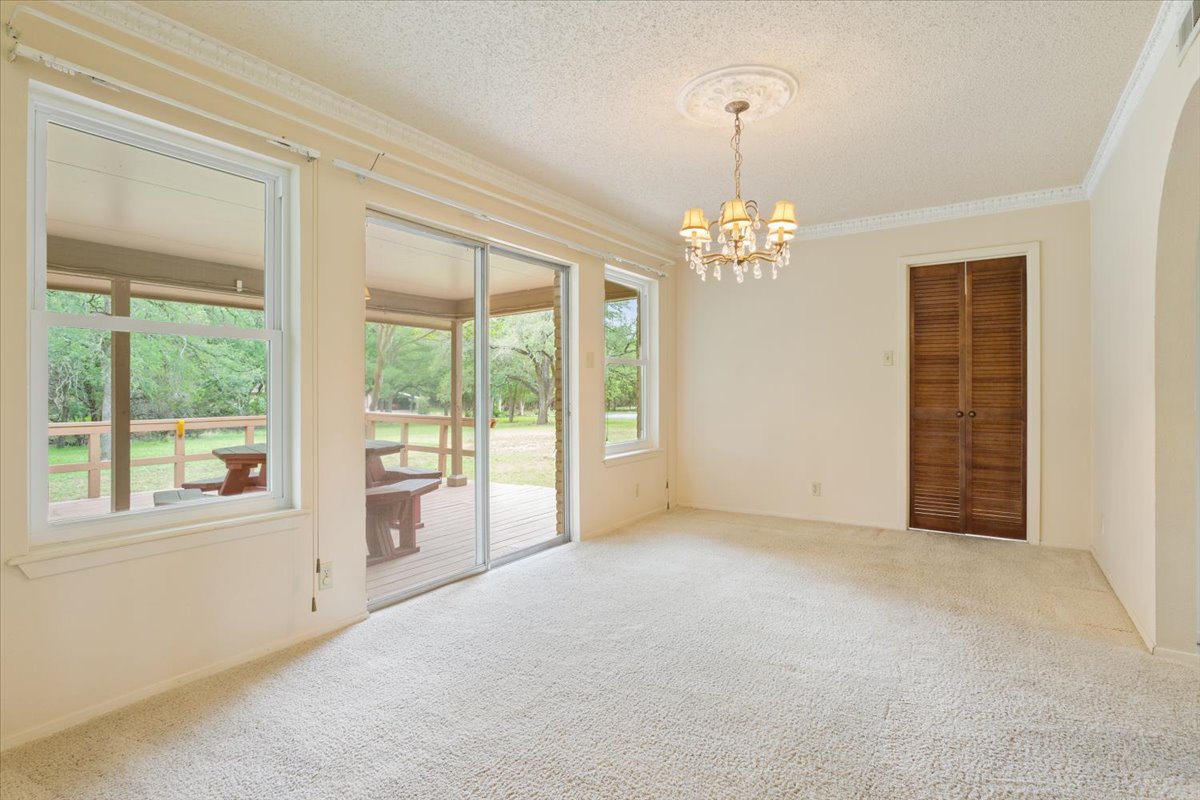 4015 Ramada Trail Georgetown, TX 78628 - Photo 13 of 35 Carpeted empty room featuring a textured ceiling, hanging lights, and crown molding