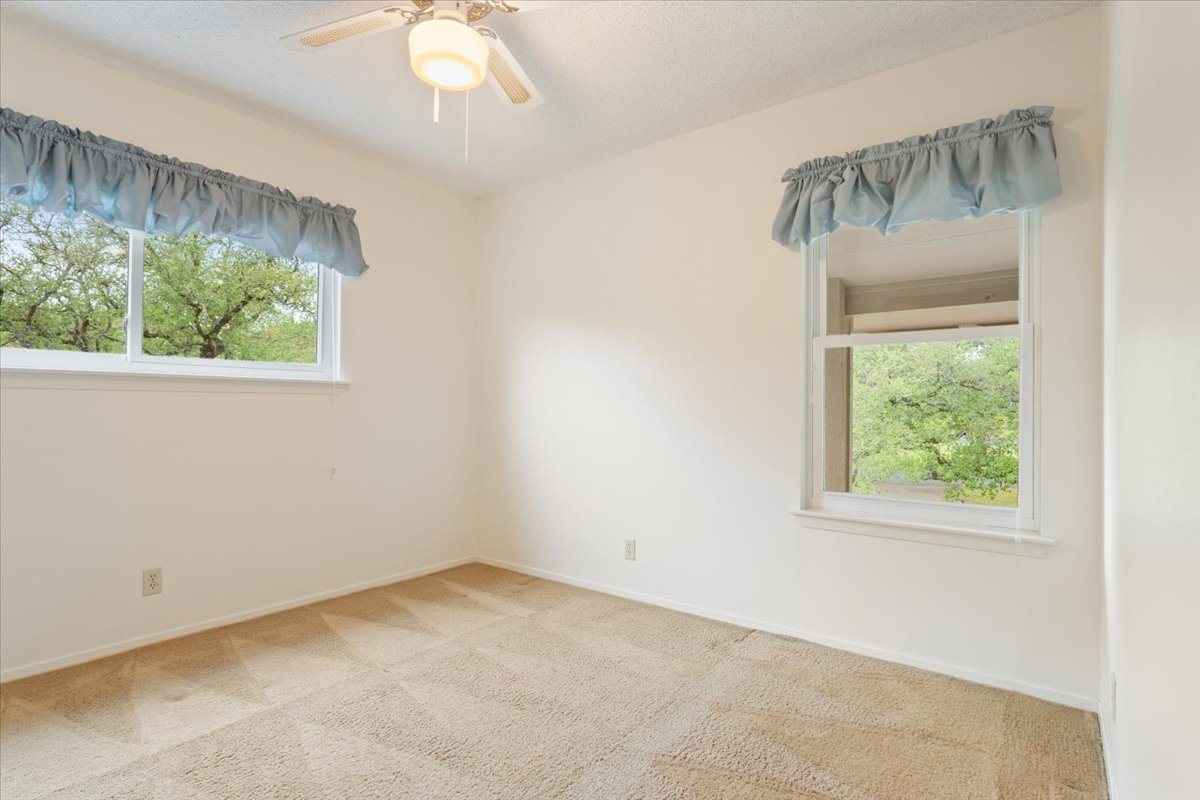 4015 Ramada Trail Georgetown, TX 78628 - Photo 27 of 35 Empty room featuring a ceiling fan, light carpet, and a textured ceiling