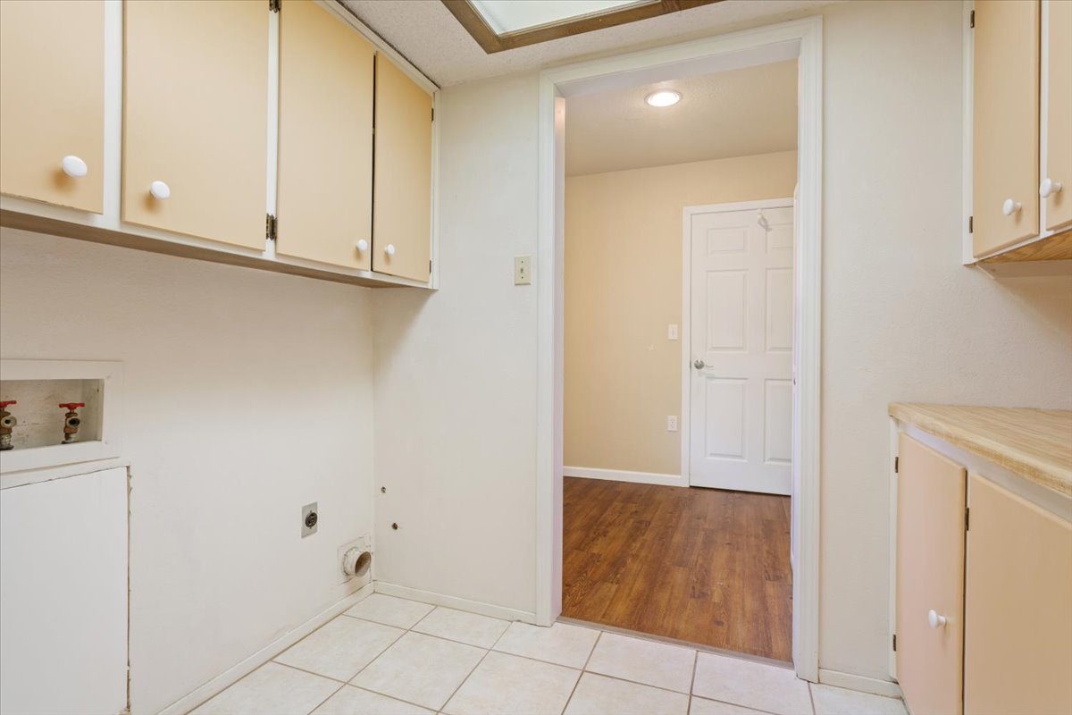 4015 Ramada Trail Georgetown, TX 78628 - Photo 29 of 35 Laundry area with cabinet space, washer hookup, light tile patterned floors, and hookup for an electric dryer