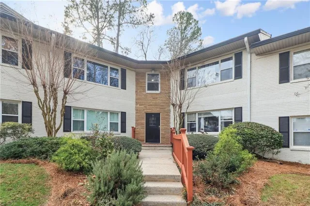 a front view of a house with a yard and potted plants