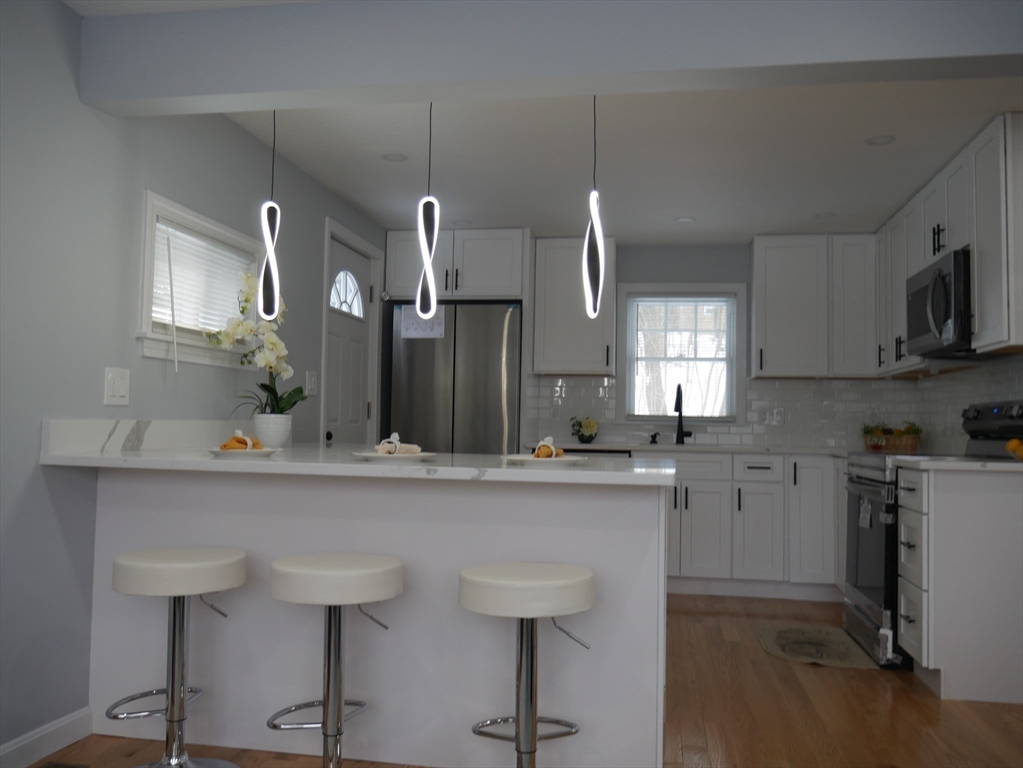 54 Harris Road Lynn, MA 01904 - Photo 5 of 41 a kitchen with stainless steel appliances a sink a stove a refrigerator cabinets and chairs