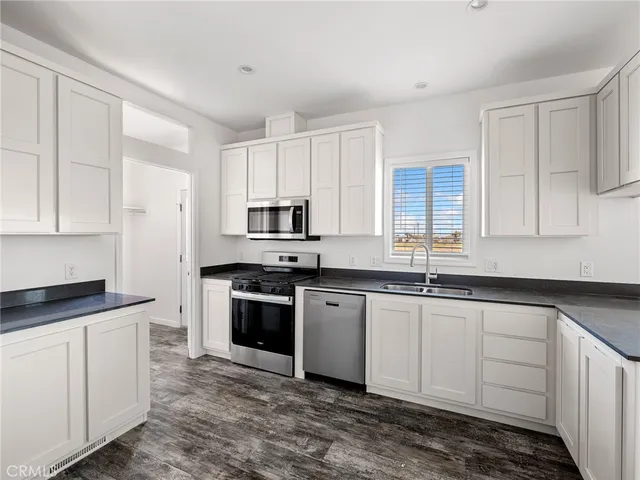 a kitchen with stainless steel appliances granite countertop a sink stove and cabinets