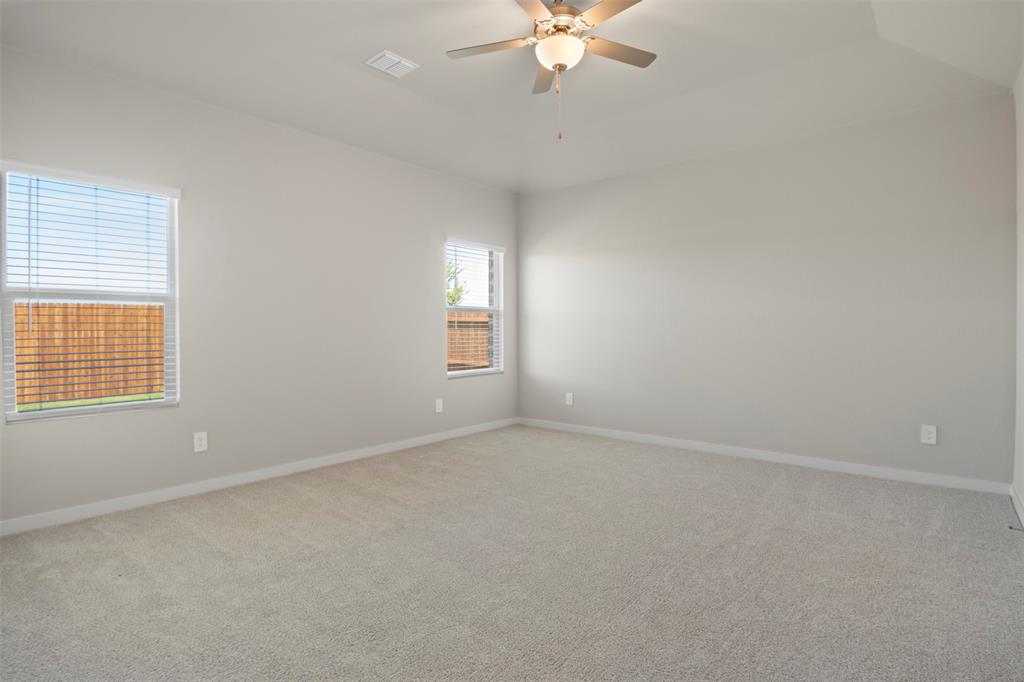 2220 Currents Road Princeton, TX 75407 - Photo 12 of 31 Light gray wall paint, multiple windows with blinds, carpeted flooring, and a ceiling fan with light fixture