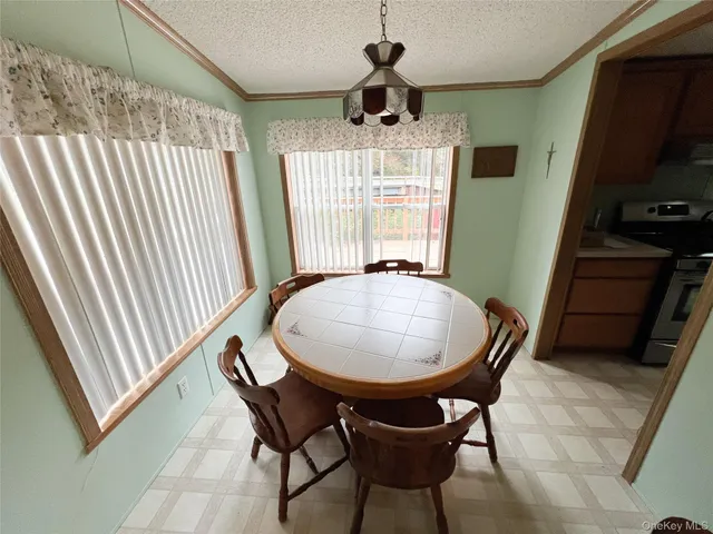 a dining room with furniture a chandelier and window