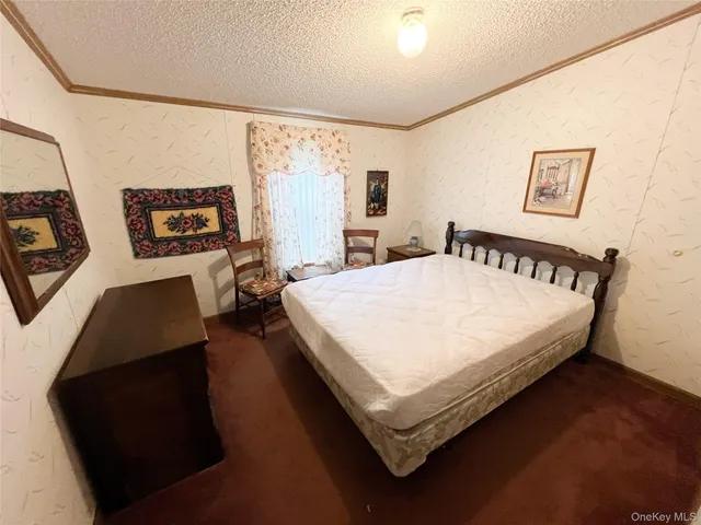 a bed sitting in a bedroom next to a window with wall paintings and a wooden floor