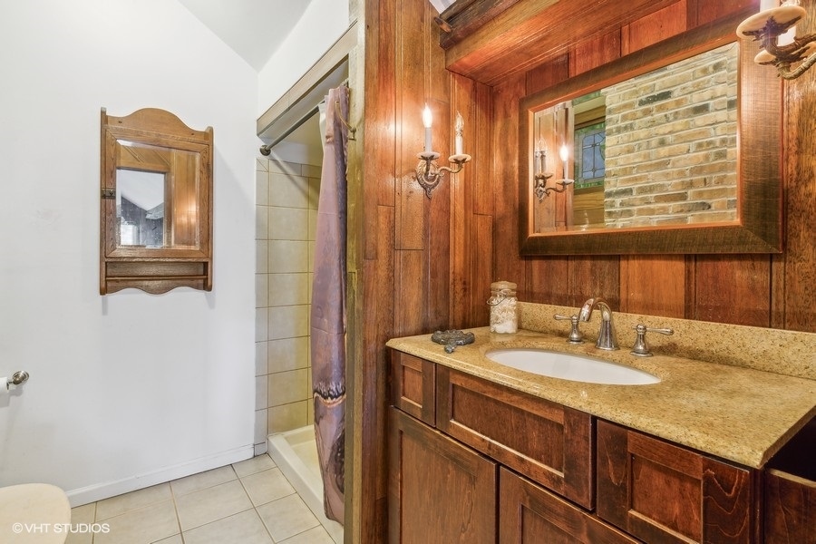 28W740 Army Trail Road West Chicago, IL 60185 - Photo 16 of 24 a bathroom with a sink a vanity and a mirror
