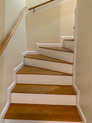 an empty room with wooden floor windows and entrance
